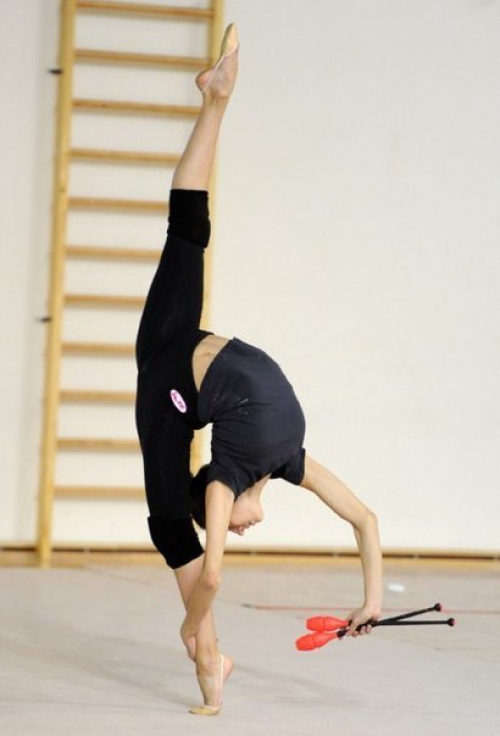 Девушка занимается художественной гимнастикой
